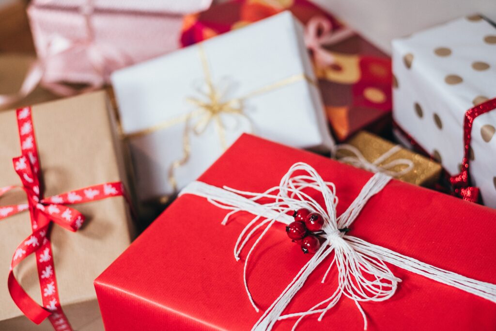Festive holiday gift boxes with red and white wrapping, ribbons and bells for eCommerce fulfillment