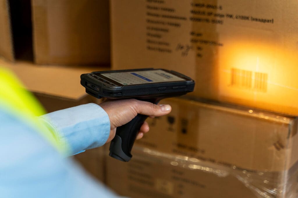 Person scanning barcode on package for eCommerce order fulfillment and shipping at iDrive Logistics