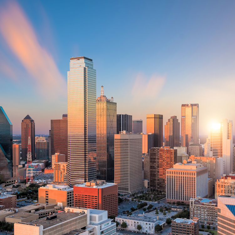 Dallas, Texas skyline at sunset with skyscrapers and office buildings lit by warm sunlight