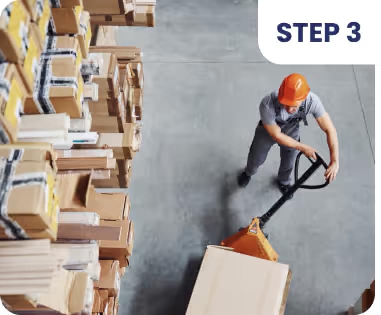 Worker moving boxes with a manual pallet jack in a warehouse, part of the order fulfillment process