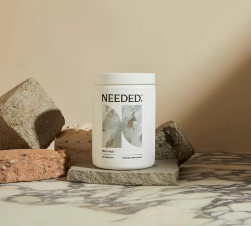 Needed protein powder jar on marble slab with bricks, alt text for eCommerce fulfillment company