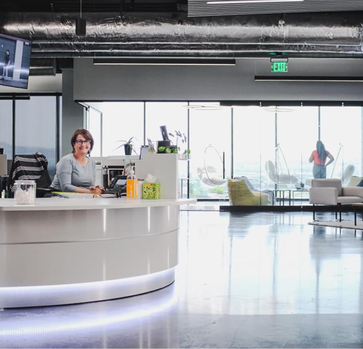Woman at reception desk in modern logistics office with high ceilings and polished floors