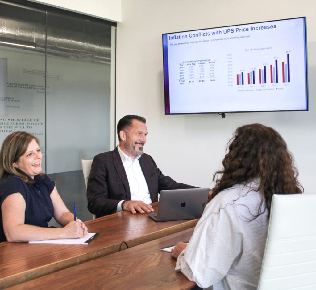 Business meeting discussing inflation conflicts with UPS price increases shown on graph