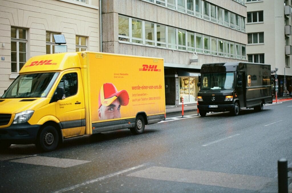A DHL and UPS truck beside each other on the same street
